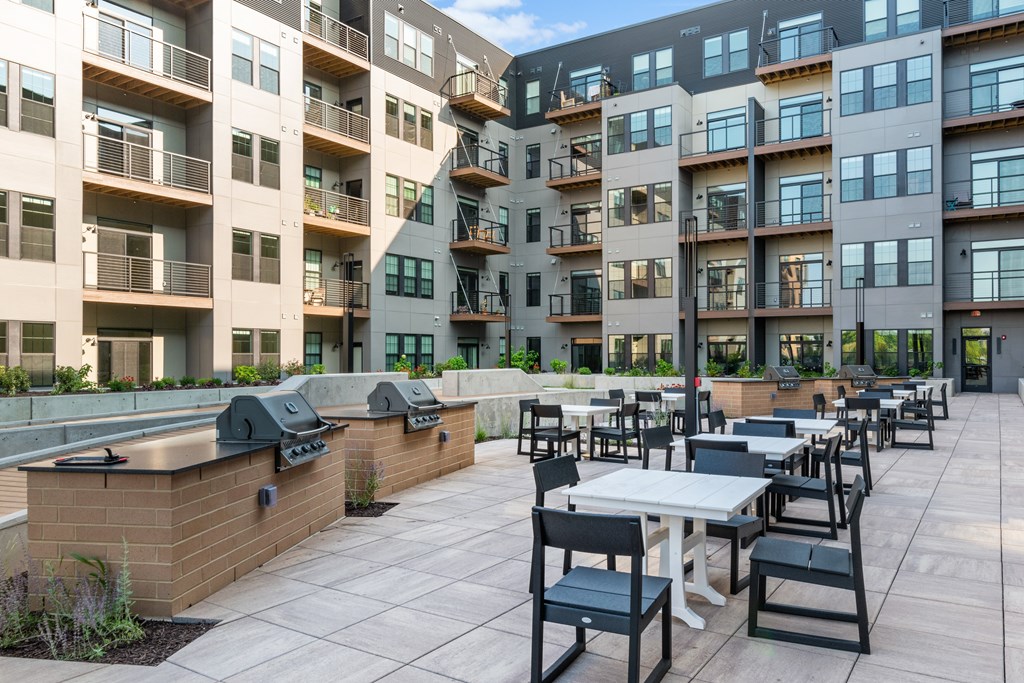 an outdoor patio with tables and chairs at the bradley braddock road station apartments